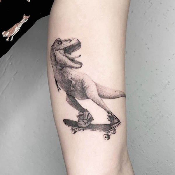 Il tatuaggio del braccio interno del T-rex pattinante di @lebedtattooing