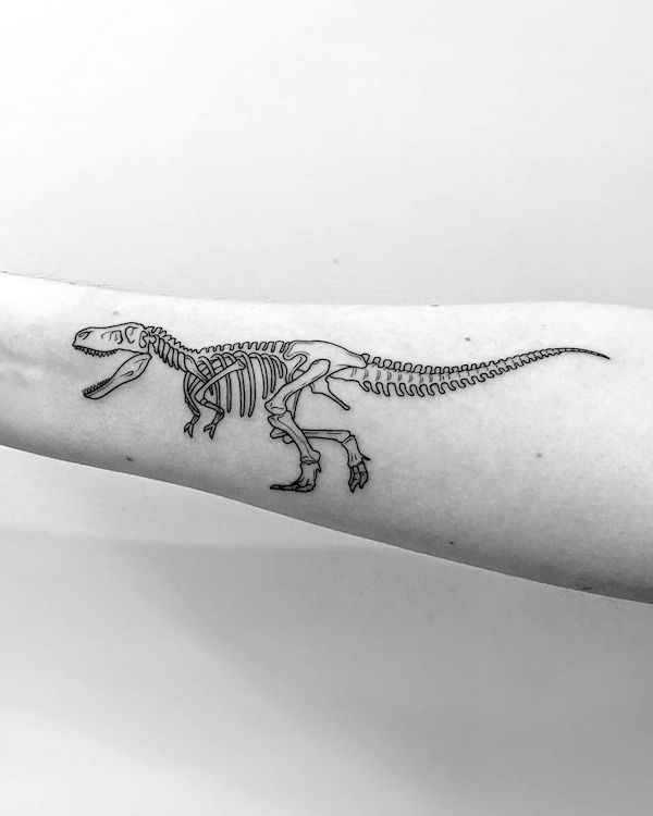 Scheletro di T-rex nero e grigio tatuato da @stephen_doyle_tattoo