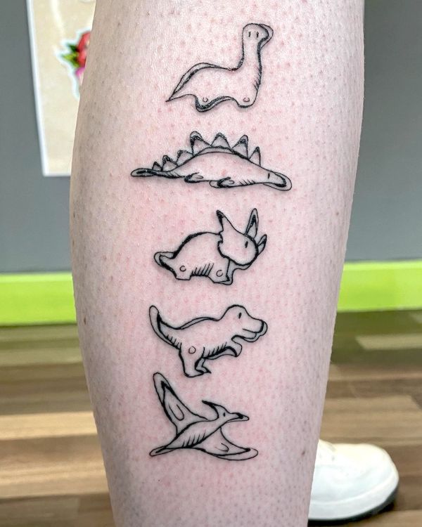 Tatuaggio di piccoli dinosauri sul polpaccio di @marksibtattoo