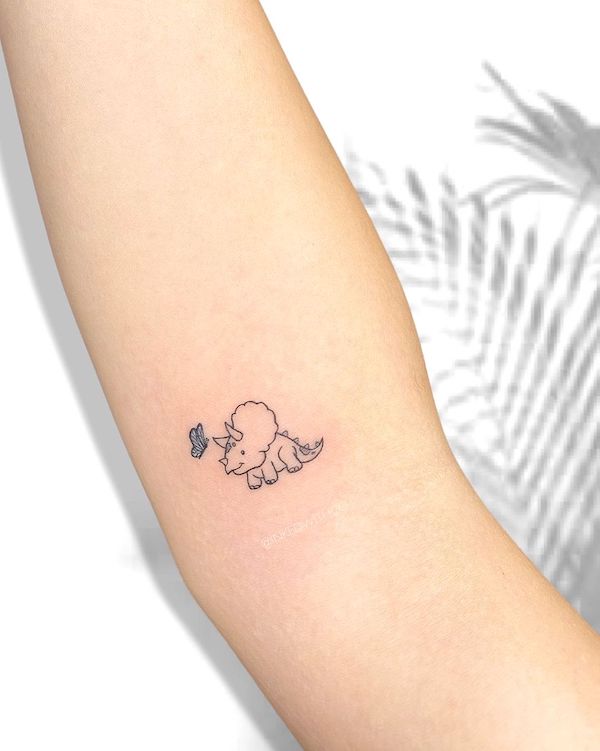 Tatuaggio con Triceratopo e farfalla all'interno del braccio di @inkedwithco