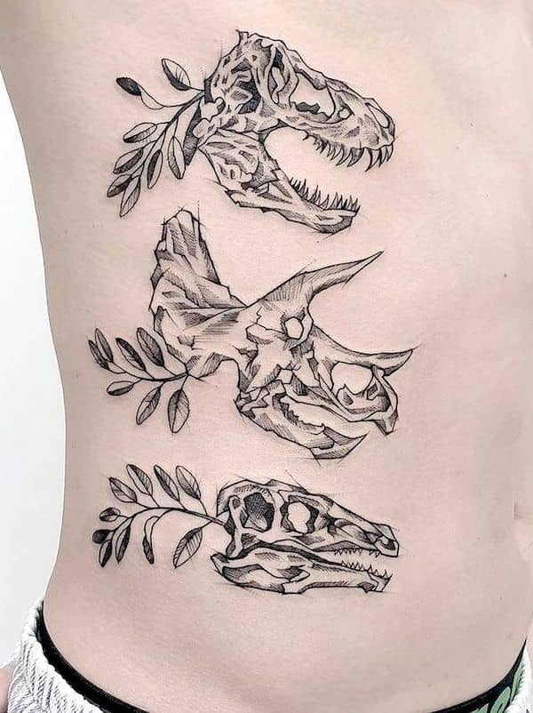 Tatuaggio di teschi di dinosauro con costole laterali di @peenutkewlee