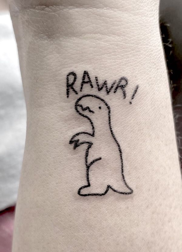 Tatuaggio minimalista del polso di un dinosauro dei cartoni animati di @lucyvandorttattoos