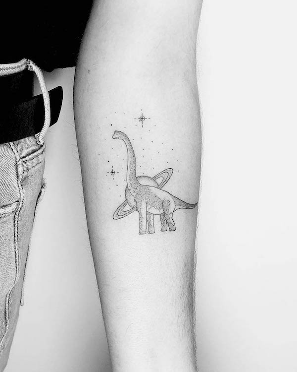 Piccolo tatuaggio diplodocus e galassia sull'avambraccio di @lotty_ink