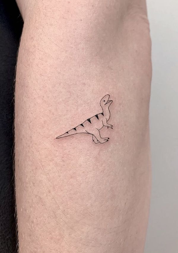 Tatuaggio sull'avambraccio di un piccolo dinosauro di @memoryinscriptions