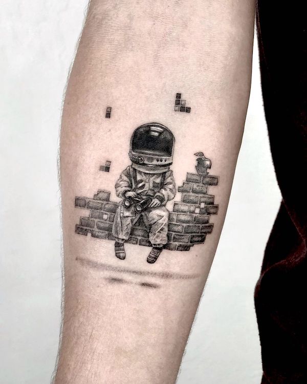 Tatuaggio con astronauta e Tetris di @dari.inks