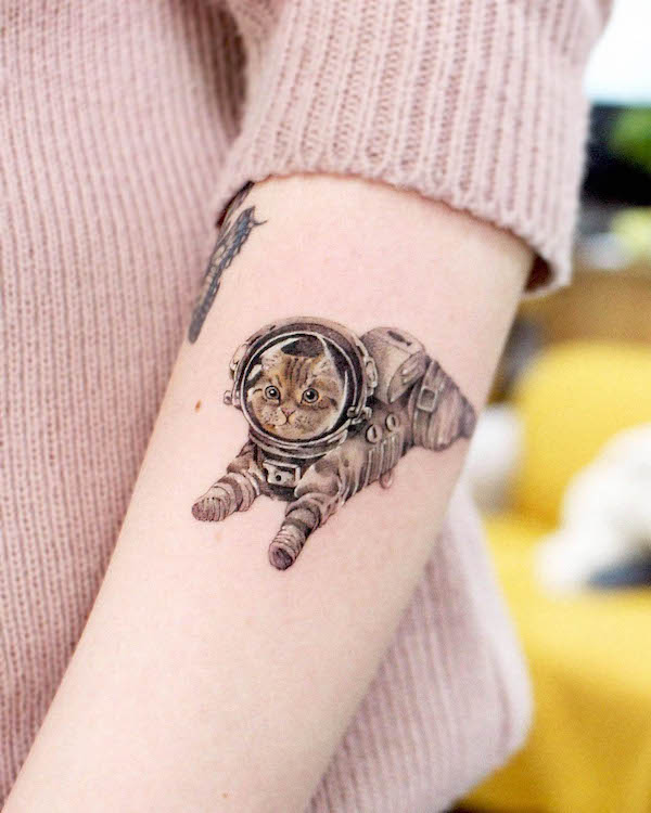 Tatuaggio di gatto astronauta sull'avambraccio da @siihee.tattoo