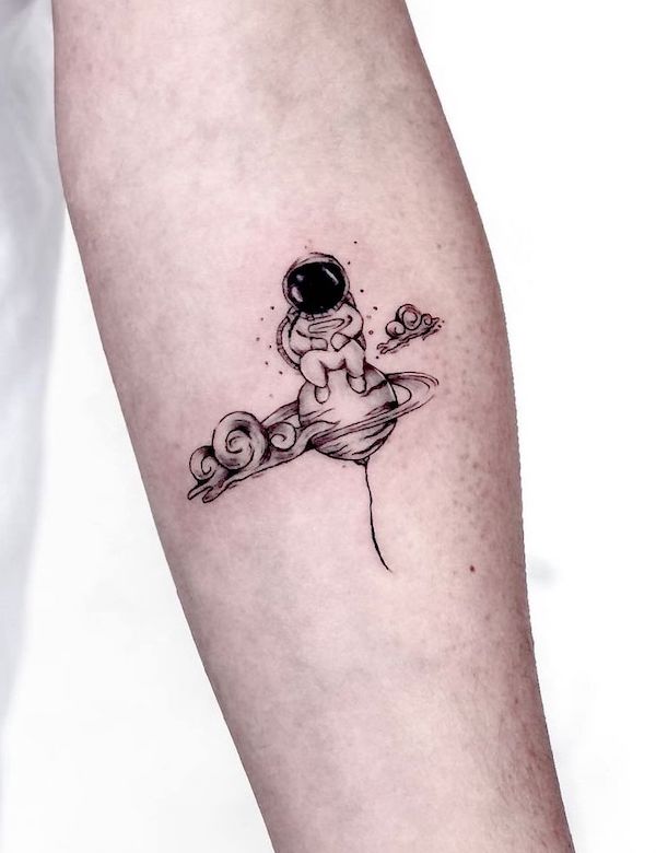 Tatuaggio carino dell'avambraccio dell'astronauta dei cartoni animati di @__yan.art_