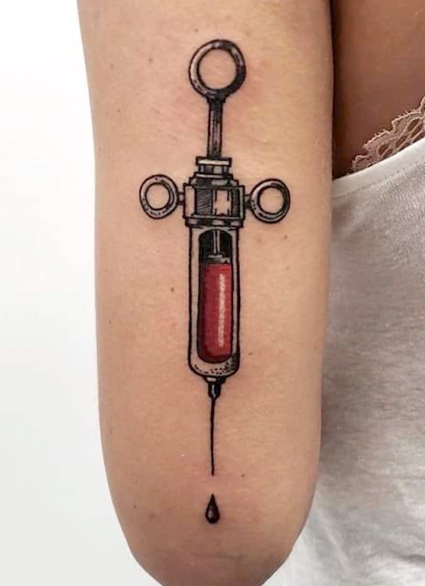 Tatuaggio a braccio con siringa di @studio.tattoo.28