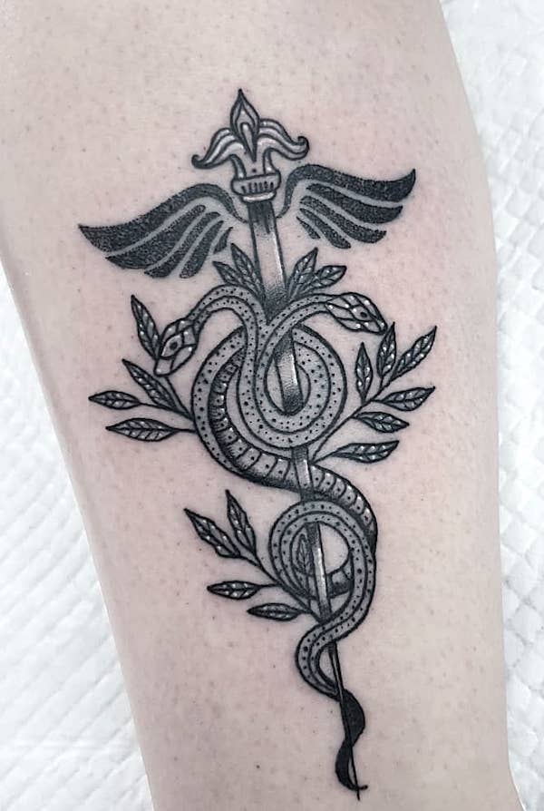 Il tatuaggio con il simbolo del caduceo RN di @wanderingwitchtattoo