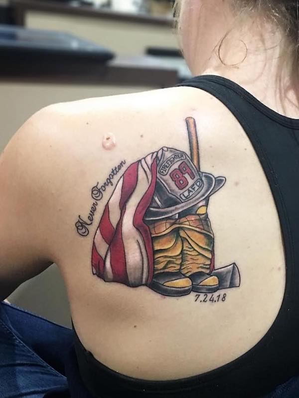 Tatuaggio con attrezzatura da pompiere sulla scapola di @ladylinework
