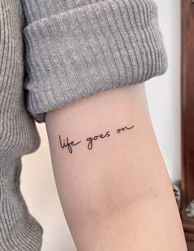 Tatuaggio con citazione Life goes on di @hezetattoo