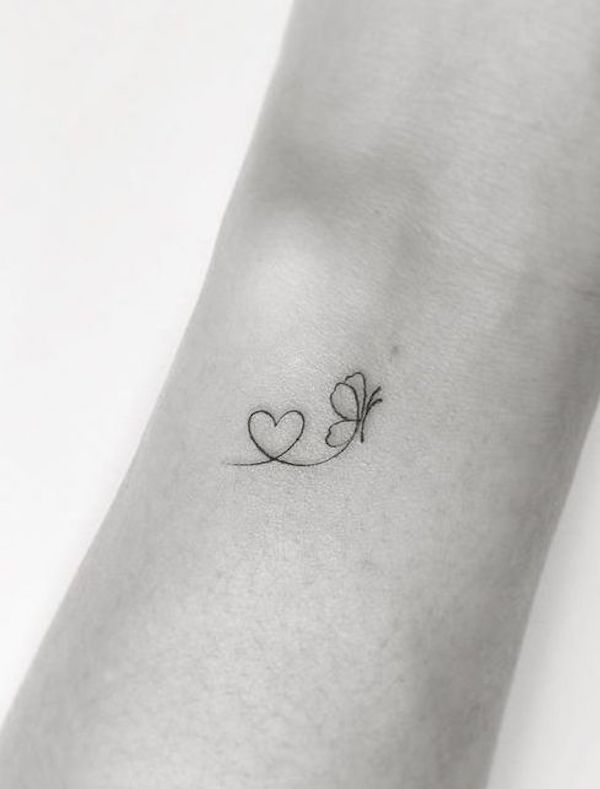 Tatuaggio con farfalla e cuore sul polso esterno di @playground_tat2
