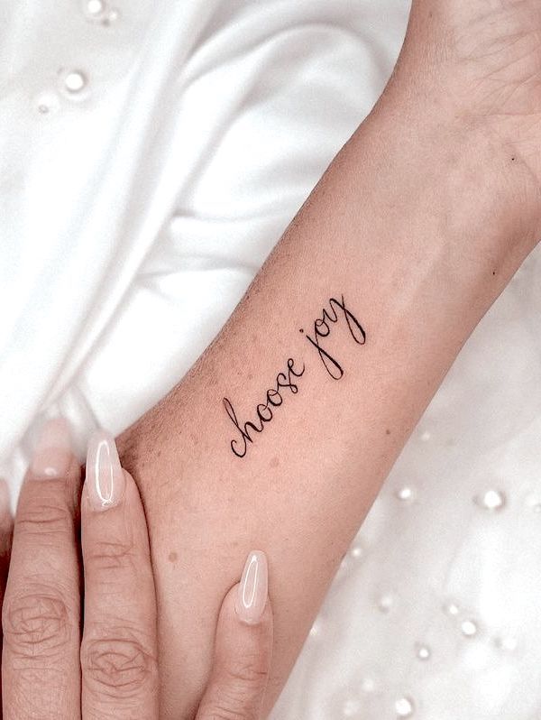 Tatuaggio da polso con citazione Choose Joy di @tinytattoos_feathertouch