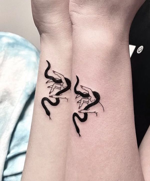 Tatuaggi laterali del polso di @atar_bar che giocano con i serpenti