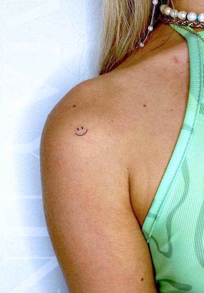 Tatuaggio con faccina sorridente sulla spalla di @mayink.nl