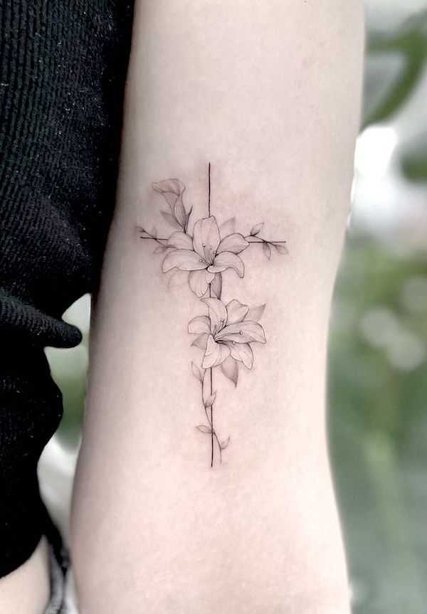 Tatuaggio con giglio e croce sul braccio di @vanya_tattoo