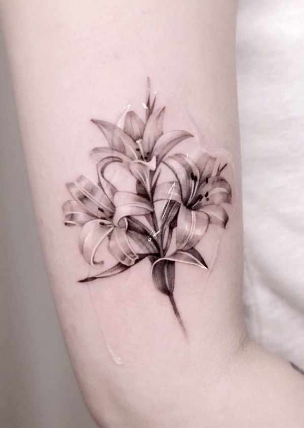 Black and white lily arm tattoo by @jku_tattoo - Tatuaggi di fiori di giglio con significato