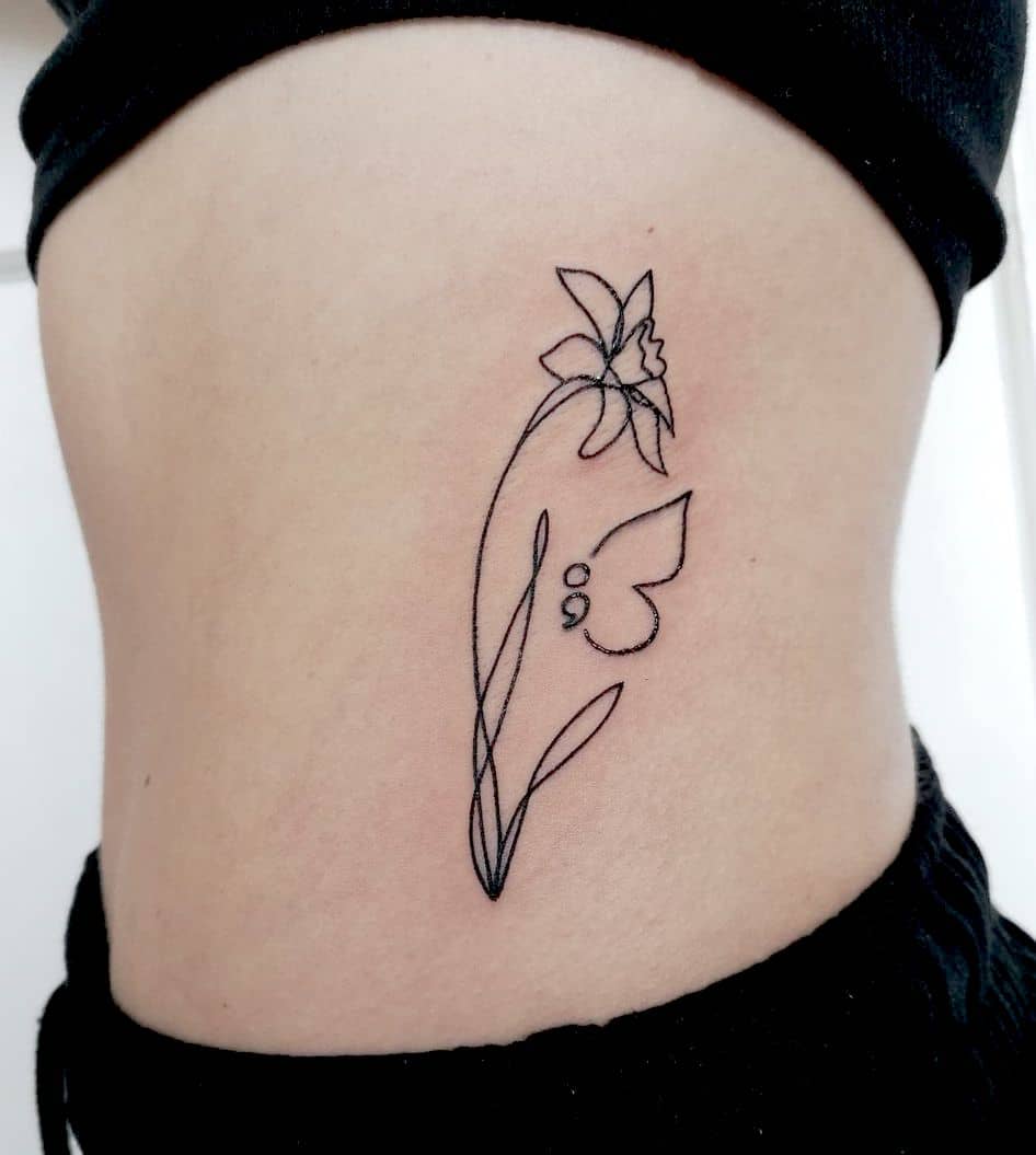 Tatuaggio astratto con narciso e farfalla con punto e virgola di @katies_tattoos