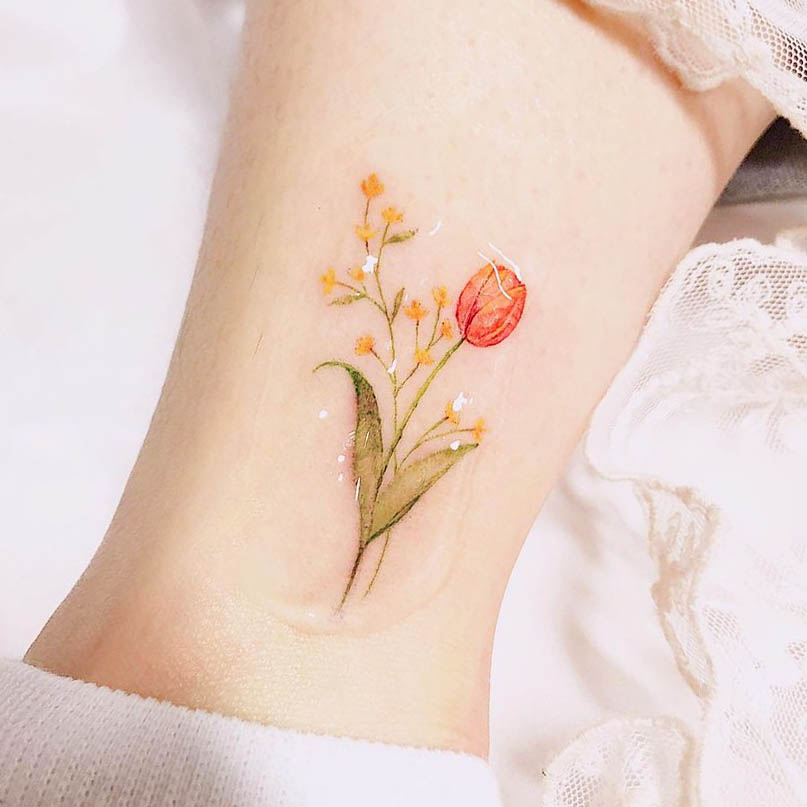 Tatuaggio alla caviglia con tulipani gialli e fiori di nebbia di @rostattoo2