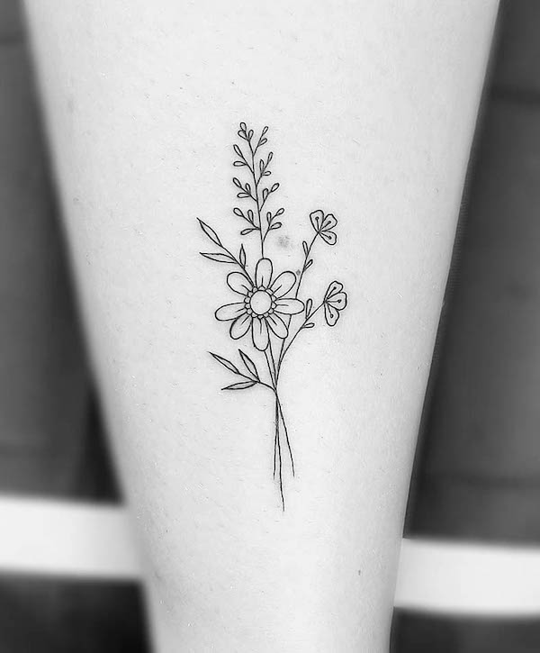 Tatuaggio di fiori selvatici sulla gamba da @tattoosbyina