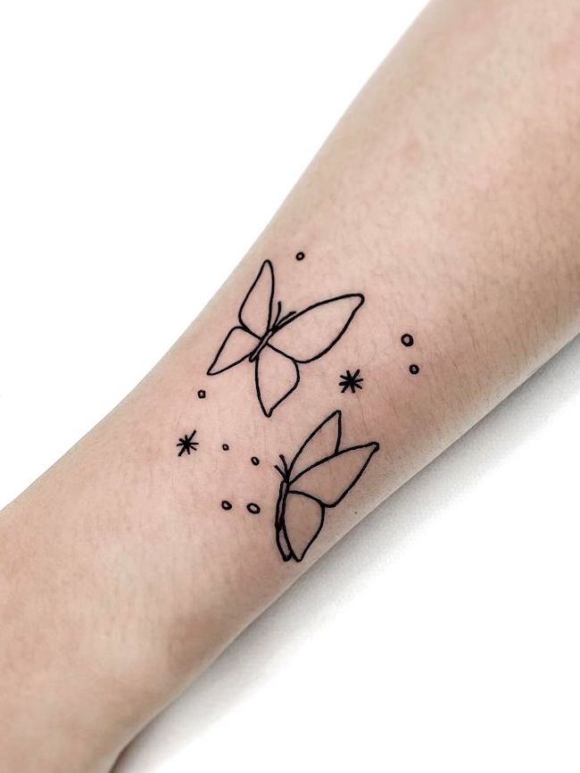 Tatuaggio del polso con contorno di farfalla di @tattooist_mauve