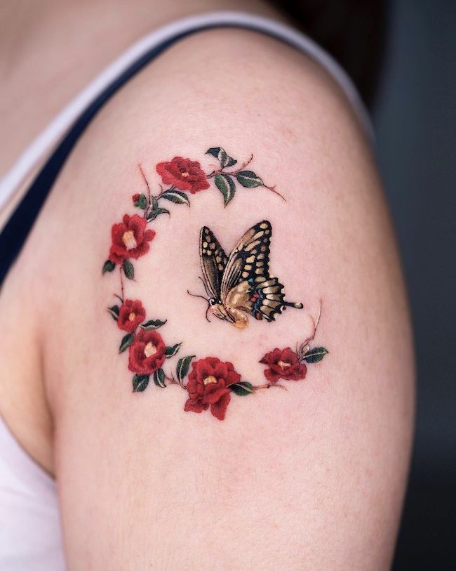 Tatuaggio con farfalla e rose di @oozy_tattoo