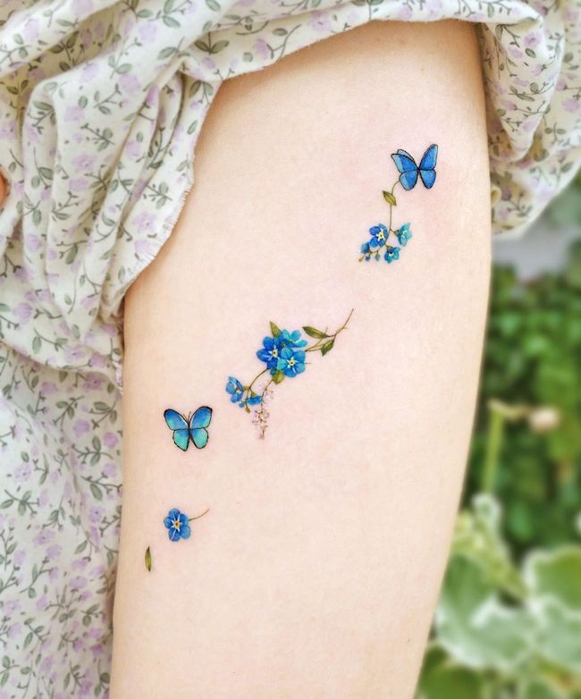 Piccolo tatuaggio di fiori e farfalle blu di @songe.tattoo