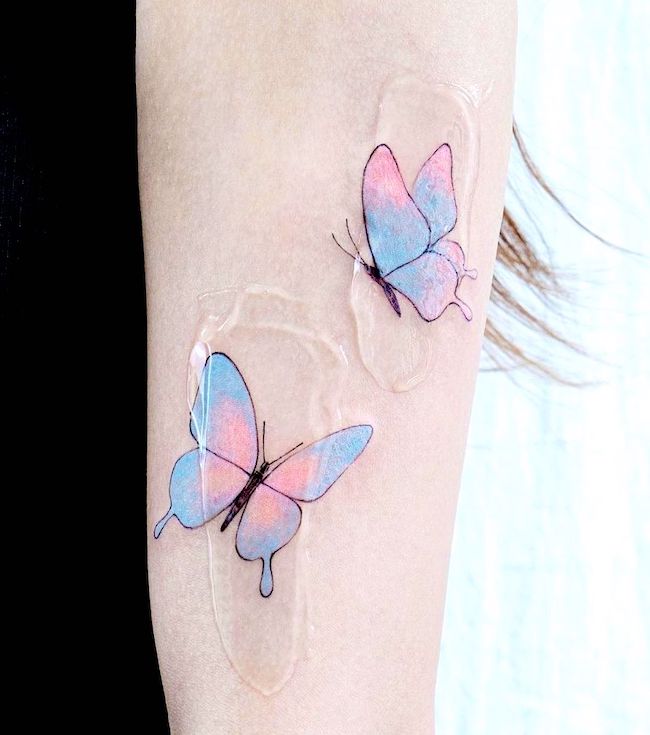 Farfalle blu e rosa sul braccio di @tattooist_color.b