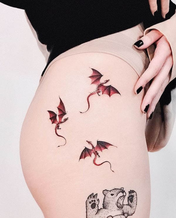 Tatuaggio dell'anca con draghi rossi di @vanzotattoo