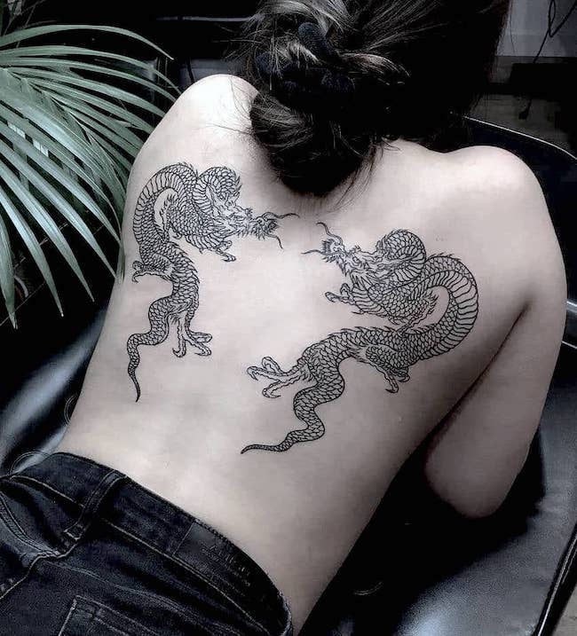 Tatuaggio simmetrico con doppio drago sulla schiena di @tattoounderground_pl