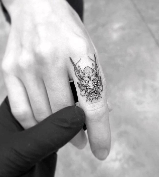 Tatuaggio tradizionale cinese con il dito a forma di drago di @tattooamazingx