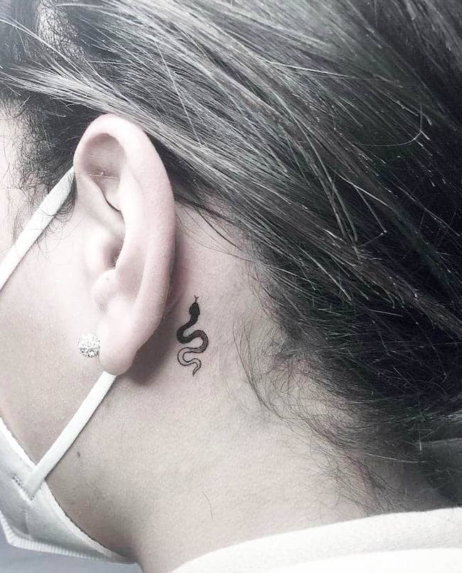 Un tatuaggio a gradiente di serpente dietro l'orecchio per ragazze cool di @moonchild.tattoo