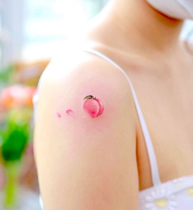 Tatuaggio sulla spalla color pesca di @xiso_ink