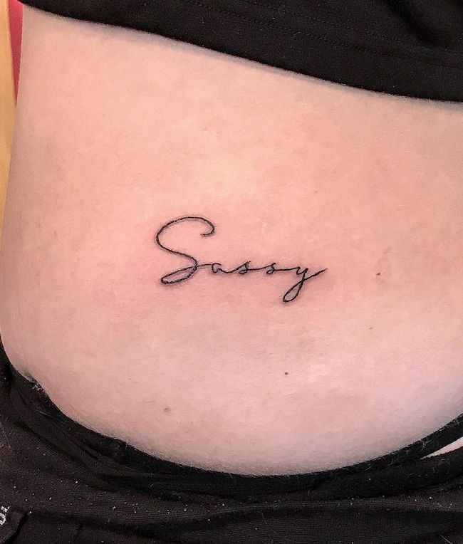 Sassy - un elegante tatuaggio script di @sacred_grove_tattoo