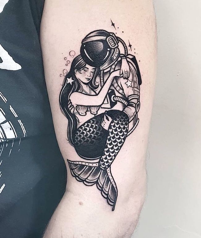 Amore tra due mondi - una sirena e un astronauta tatuati da @paperboy_tattoo