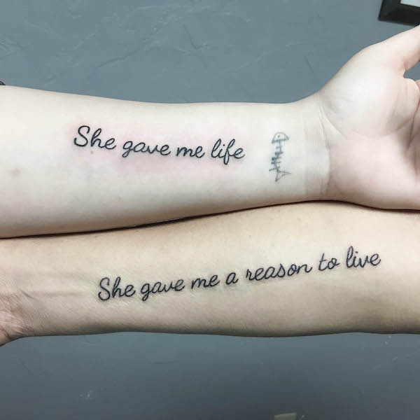 Tatuaggio bicipite con citazione madre-figlia di @jackquackart