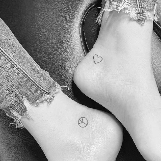 Simboli di pace e amore sulla caviglia di @nillo.ink- Tatuaggi minimalisti per coppie