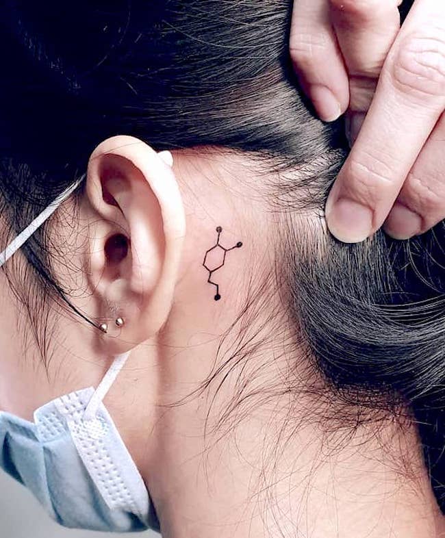 Tatuaggio con dopamina dietro l'orecchio di @val_tattooer