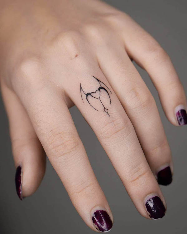 Piccolo diavolo e angelo tatuati sulle dita da @nurai.tattoo