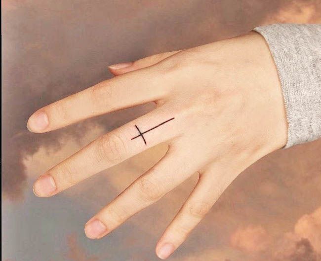 Tatuaggio a forma di croce sul dito medio di @pomme_tat- Idee per tatuaggi sulle dita più delicate