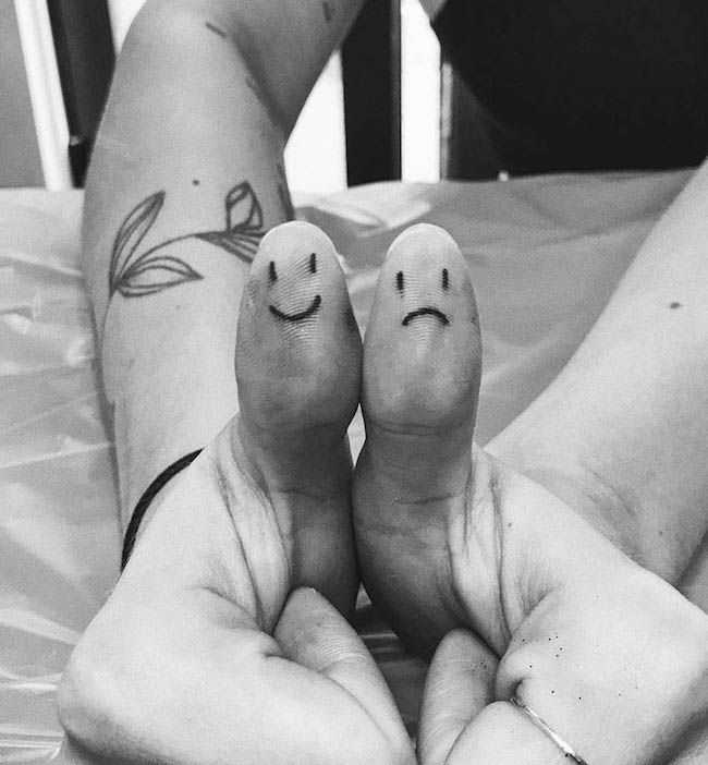 Tatuaggi del pollice con faccia felice e triste di @ziggiestattoo- Tatuaggi del pollice creativi