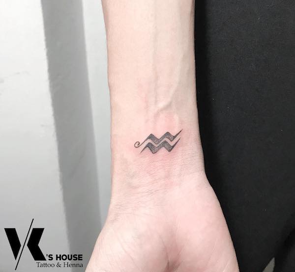 Un semplice tatuaggio da polso in stile blackwork per gli uomini dell'Acquario by @khoaartist92
