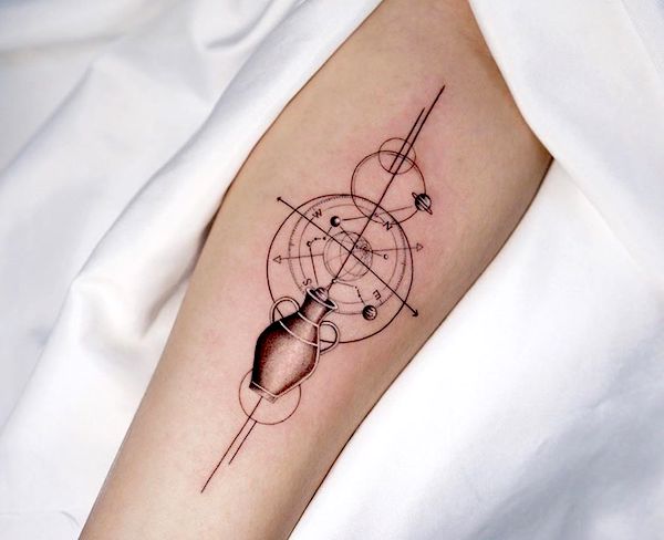 Tatuaggio di una bussola con la costellazione dell'Acquario e il vascello di @dan_tattooer