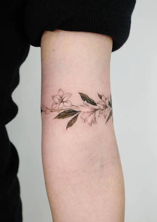 Tatuaggio bracciale con fiori e foglie di @donghwa_tattoo