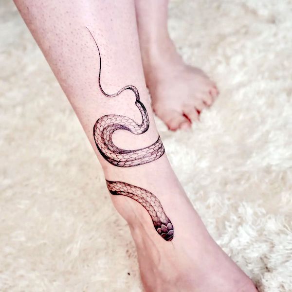 Elegante tatuaggio a forma di serpente intorno alla caviglia @jay_tattooist