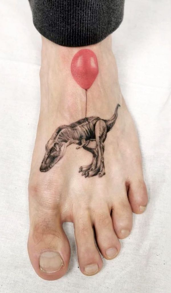 Tatuaggio con piede di T-rex e ballon di @ikarus.abendwind